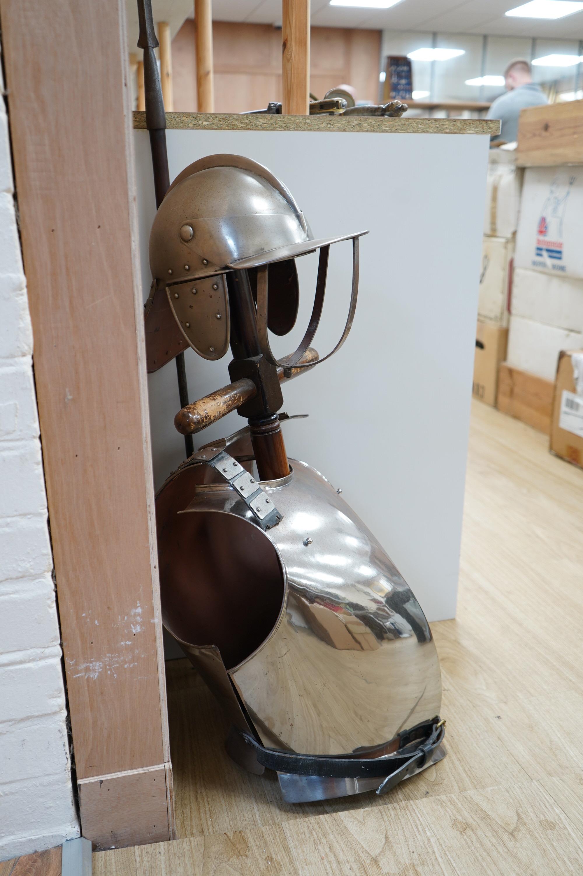 A replica suit of English Civil War armour on a stand, comprising; a lobster pot helmet, breastplate and back plate. Condition - poor to fair